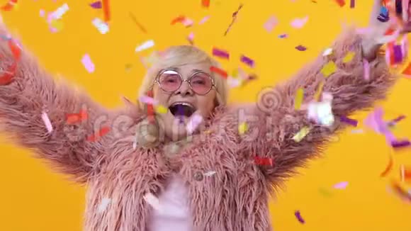 快乐的老太太时尚的皮草享受飘落的五彩纸屑节日的快乐视频的预览图