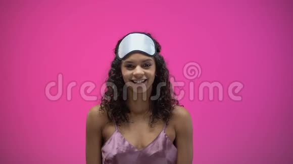睡意朦胧的非裔美国妇女早上醒来后伸展身体精力充沛视频的预览图