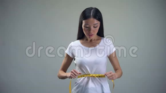 痴迷的女人收紧她腰部的测量磁带渴望苗条暴食症视频的预览图