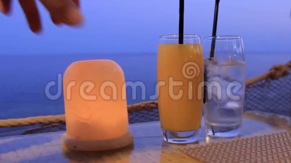 在海滨附近的酒吧里一张桌子上摆着两杯鸡尾酒视频的预览图
