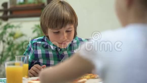 男孩在餐馆里闻着比萨饼和朋友一起庆祝生日视频的预览图