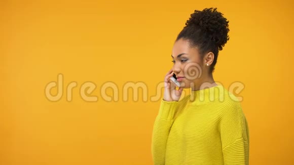 开朗的美国黑人妇女在讲电话听到好消息流言蜚语很兴奋视频的预览图