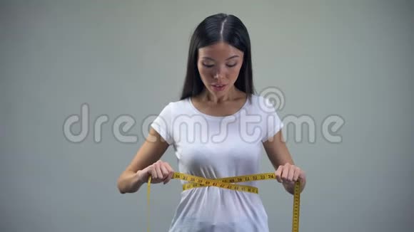 亚洲女性测量腰部对训练和饮食结果满意适合视频的预览图