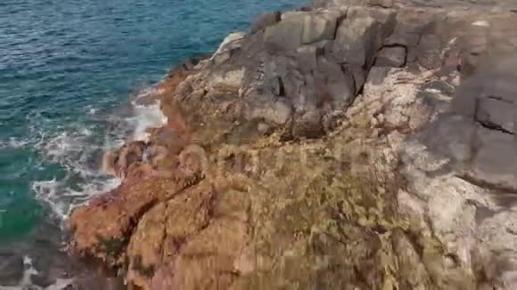 空中射击海浪海浪溅起蓝色和绿松石火山般的石头和干燥的石化海岸线视频的预览图