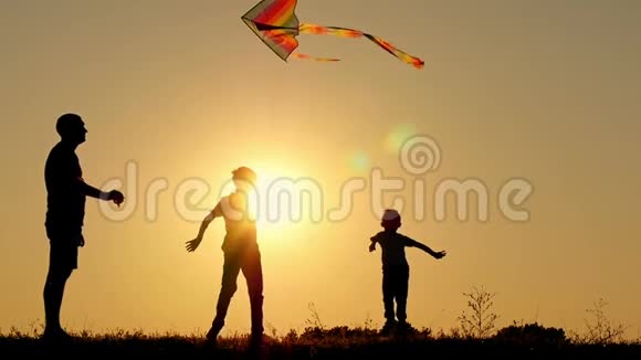快乐的父亲把蛇带到空中两个孩子在玩嬉戏跳过风筝家庭团结视频的预览图