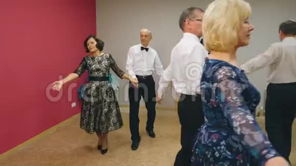 在舞蹈俱乐部跳华尔兹的快乐的老年夫妇在舞蹈晚会上表演华尔兹的成熟男女视频的预览图