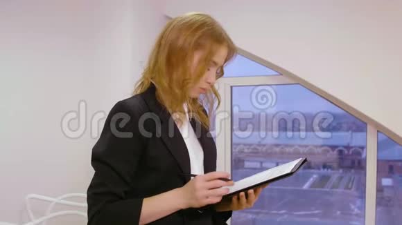 以窗口为背景在办公室处理文档文件的女商人视频的预览图