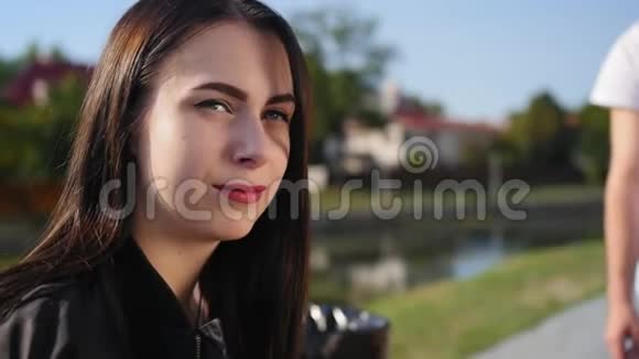 女性肖像特写迷人的女孩黑色长发和红色嘴唇在背景池塘里近距离射击视频的预览图