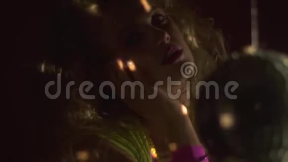 迪斯科舞厅灯光照耀着复古派对黑暗中的金发女人慢动作视频的预览图
