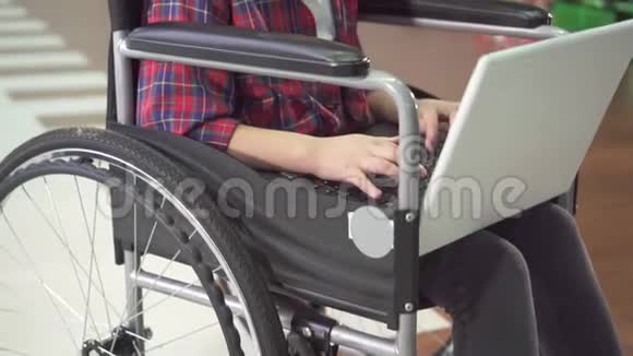 一个坐在轮椅上的少女使用笔记本电脑和互联网社交网络的画像慢了莫视频的预览图