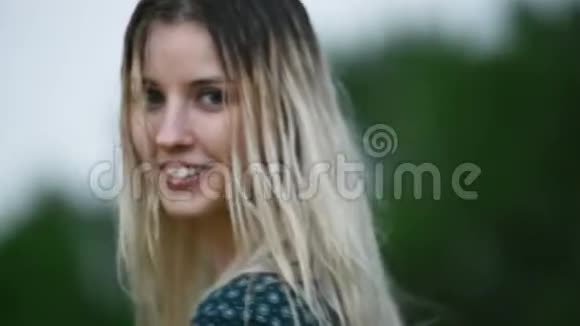 在户外的一场雨中一位美丽迷人的白人金发女孩头发湿漉漉的在大自然中的一幅特写照片视频的预览图
