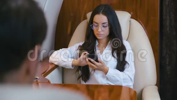 商务人士乘坐私人飞机旅行女商人和商人正在商务舱乘坐飞机A视频的预览图