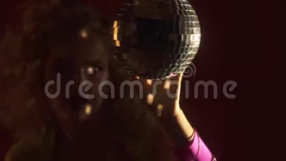 穿着80年代服装的年轻女子玩吊迪斯科球视频的预览图