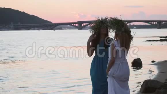 两个美丽的女孩在河岸边谈话视频的预览图