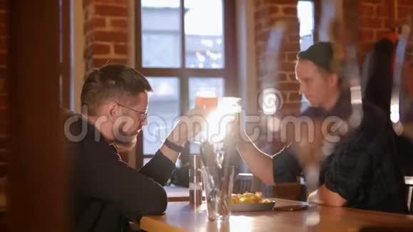 两个人坐在餐厅的桌子旁喝着啤酒视频的预览图
