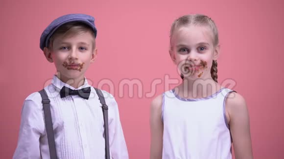 快乐的男孩和女孩微笑着吃着巧克力糖果庆祝节日视频的预览图