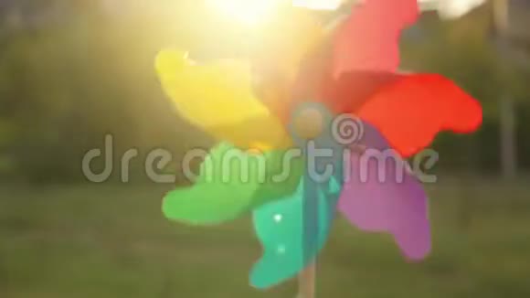 塑料彩虹风车在夕阳下旋转视频的预览图