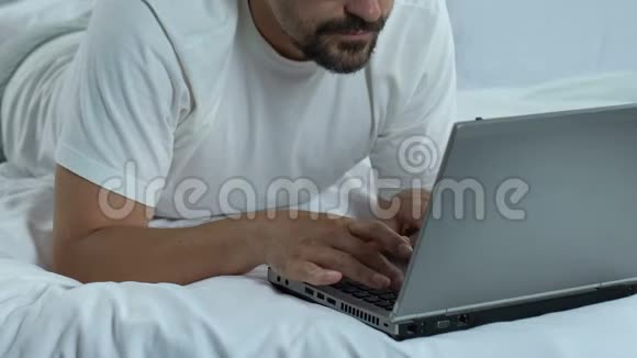 疲惫的自由职业者在家里的床上工作劳累过度的男人压力视频的预览图