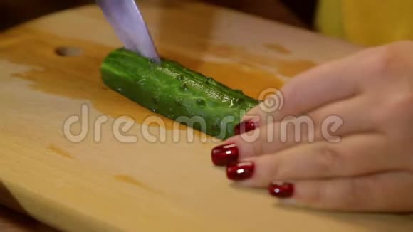 女人把新鲜黄瓜切在木板上视频的预览图