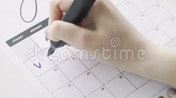 女人用紫罗兰的手笔写日历词假期视频的预览图