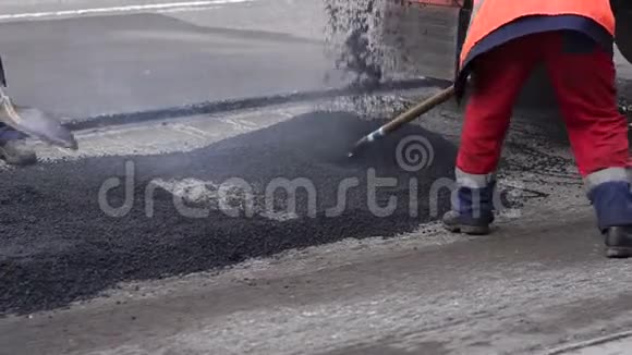 糟糕的路压路机和工人在沥青和修理城市街道视频的预览图