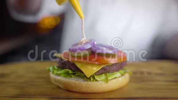 厨师做多汁的汉堡并倒入辛辣的酱汁在快餐店烧烤汉堡4kUHD做汉堡视频的预览图