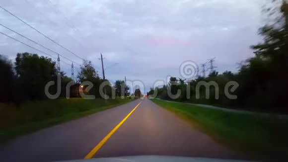 开车穿过乡村在地平线上接近城市的灯光从推动进入城市的角度看视频的预览图