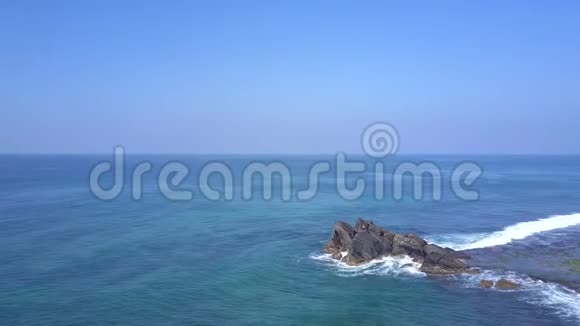 女士在一望无际的蓝色海洋上冥想巨大的岩石悬崖视频的预览图