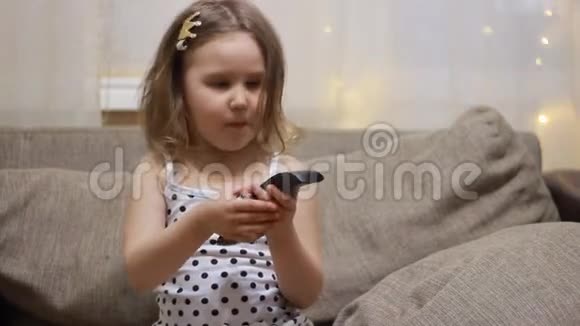孩子用遥控器打开电视小女孩看电视视频的预览图