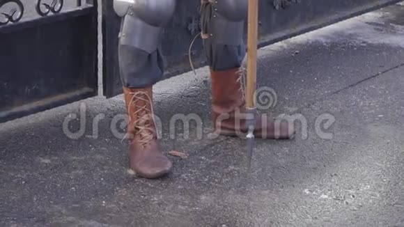 一个穿着金属西装和棕色靴子的骑士站在大门附近视频的预览图