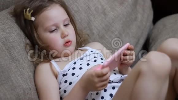孩子在手机上玩游戏女孩在智能手机上下载应用程序视频的预览图