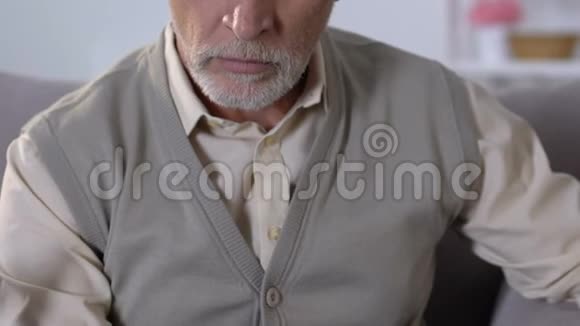 老人坐在沙发上摸着下巴想着生活问题视频的预览图