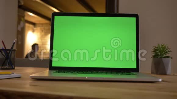 电脑绿色屏幕特写镜头躺在办公室的办公桌上员工在办公室互动视频的预览图