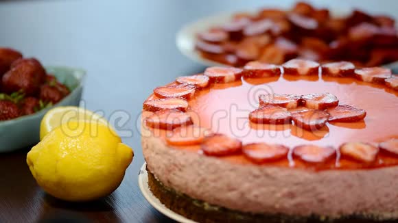 在一位糕点厨师手上的特写镜头轻轻地放一个草莓让他的草莓蛋糕达到最后的效果视频的预览图