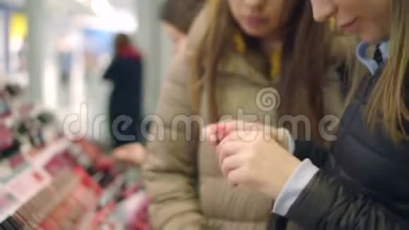 在化妆品部门漂亮的年轻女性尝试用她手上的新口红视频的预览图