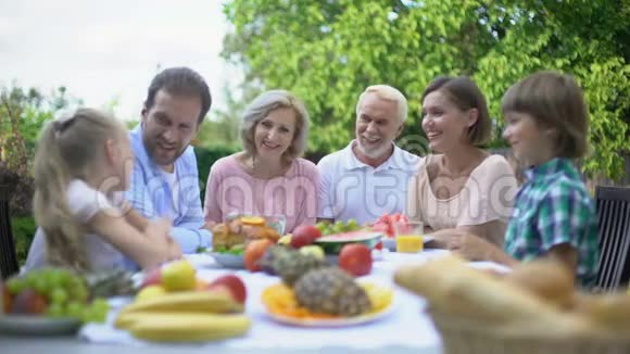 大家庭在户外吃饭时聊天一起享受时光庆祝视频的预览图