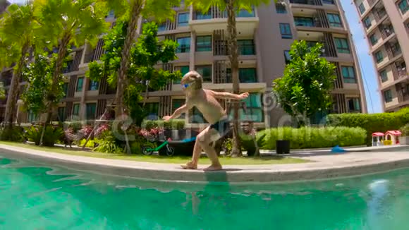小男孩跳进游泳池的慢镜头视频的预览图