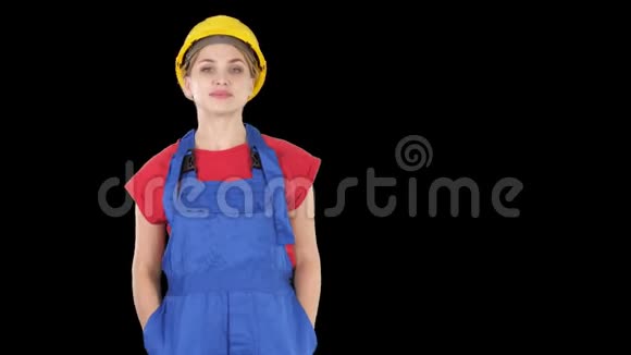 微笑的建筑工人妇女站着变换姿势双手折叠双手放在臀部双手放在口袋里阿尔法频道视频的预览图