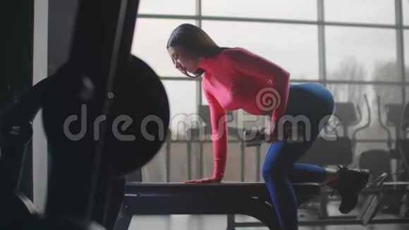 女人在健身房用哑铃做运动视频的预览图