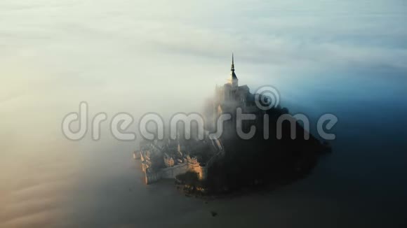 史诗般的空中拍摄虚幻的圣米歇尔岛城堡覆盖着惊人的日出雾云在诺曼底流动视频的预览图