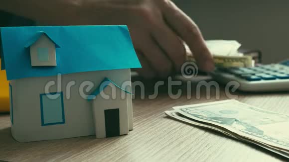 抵押概念房子的模型和数钱的过程视频的预览图