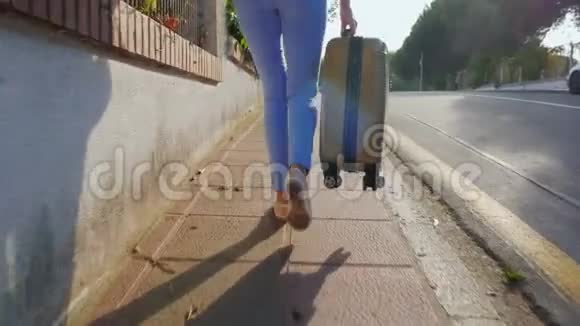 stadicam镜头带着旅行袋在路上行走的女游客西班牙度假胜地背面视频的预览图