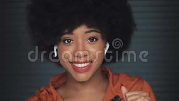 年轻快乐的非洲裔美国妇女戴耳机听音乐跳舞的镜头视频的预览图