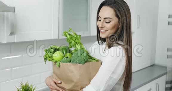 女人拿着绿色蔬菜包视频的预览图