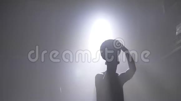 篮球运动员剪影投掷球圈烟雾四处背景泛光灯视频的预览图