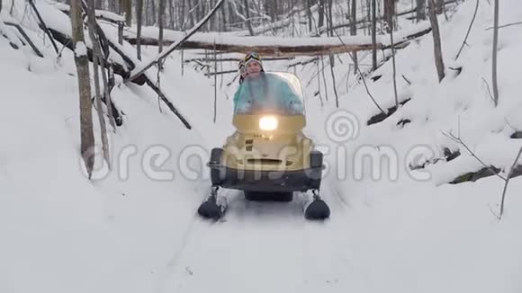 冬季森林乘坐雪上摩托的年轻人沿着特殊的轨道行驶视频的预览图