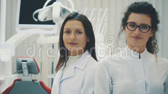 办公室里有两个牙医年轻漂亮的女人彼此站着看着摄像机累了视频的预览图