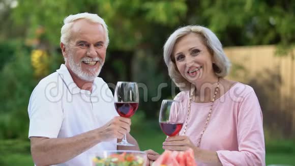 带着酒杯微笑的老夫妇庆祝结婚纪念日家庭传统视频的预览图