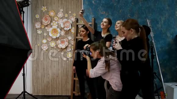 年轻女子模特在摄影棚拍照摄影师拍摄其他模特自拍视频的预览图