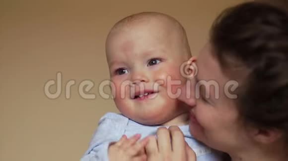 妈妈抱着他的儿子他挥舞着双手微笑着宝宝的发育长达一年妈妈天视频的预览图